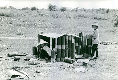 תצלום וינטג 'של המקומיים הווייטנאמיים אוספים קליפות תותח ריקות.